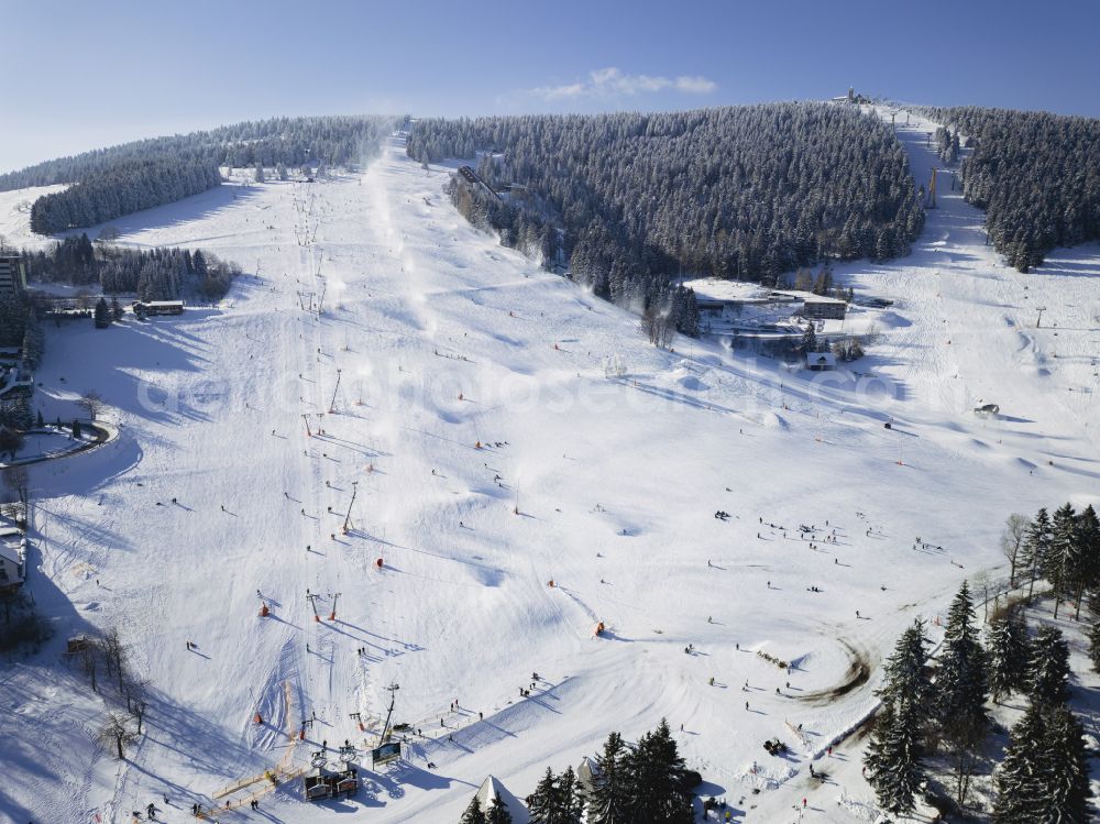 Kurort Oberwiesenthal from the bird's eye view: Wintry snowy wintry snowy mountain slope with downhill ski slope and cable car - lift on Fichtelberg in Kurort Oberwiesenthal in the state Saxony, Germany