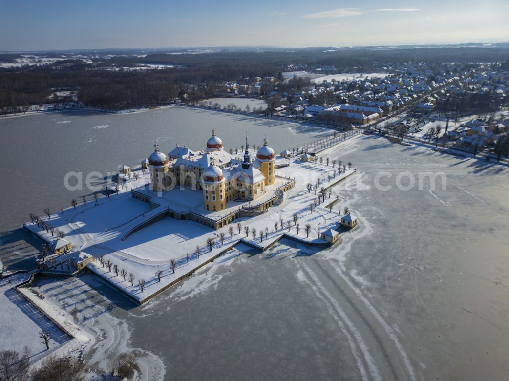 Aerial image Moritzburg - Wintry snowy winterly snow-covered hunting and moated castle and castle park in the castle pond in Moritzburg in the federal state of Saxony, Germany