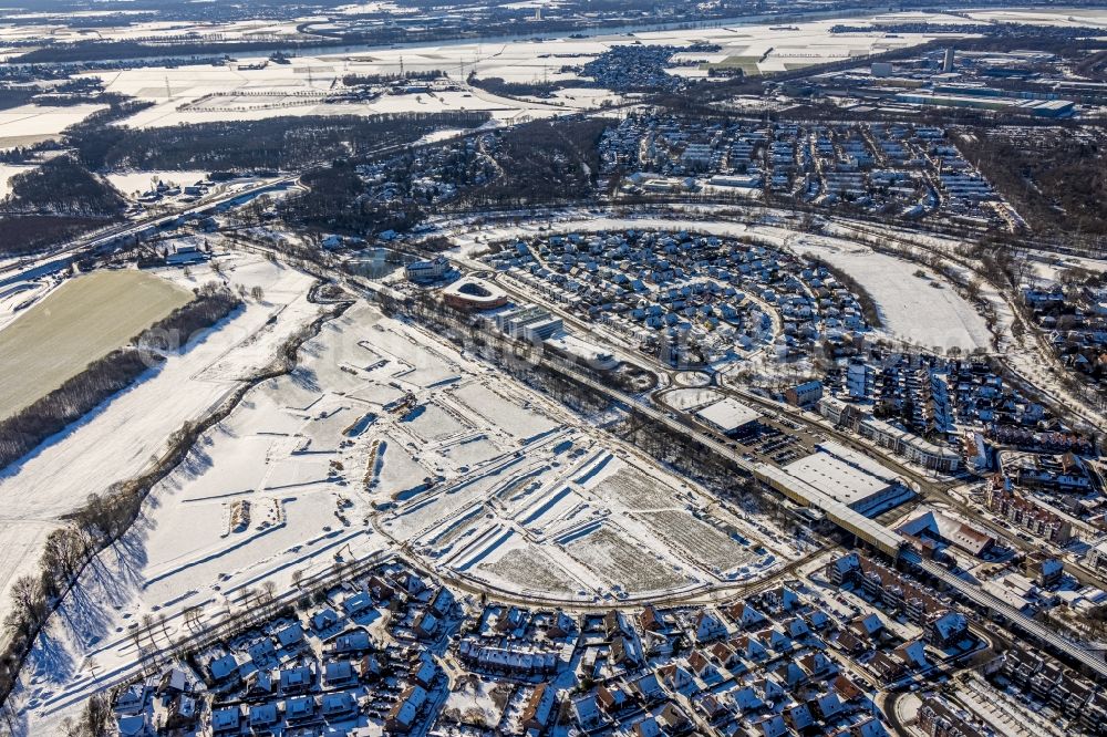 Aerial photograph Duisburg - Wintry snowy single-family residential area of settlement along the Heinz-Troekes-Strasse - Johannes-Molzahn-Strasse overlooking the office buildings of the Infineon Technologies AG and the Xella International GmbH in Duisburg at Ruhrgebiet in the state North Rhine-Westphalia, Germany