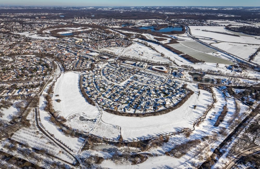 Aerial image Duisburg - Wintry snowy single-family residential area of settlement along the Heinz-Troekes-Strasse - Johannes-Molzahn-Strasse overlooking the office buildings of the Infineon Technologies AG and the Xella International GmbH in Duisburg at Ruhrgebiet in the state North Rhine-Westphalia, Germany