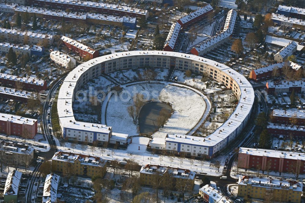 Aerial photograph Berlin - Wintry snowy Residential area of the multi-family house settlement Hufeisensiedlung on Lowise-Reuter-Ring - Fritz-Reuter-Allee in Britz in the district Neukoelln in Berlin, Germany