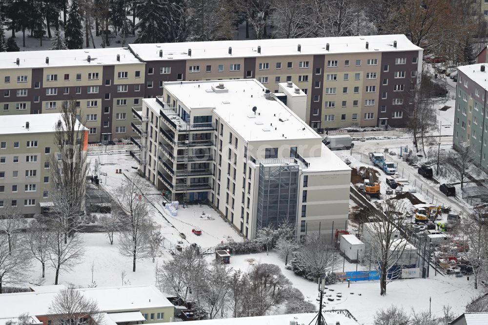 Bernau from the bird's eye view: Wintry snowy construction site of Dorm residential care home - building for the physically handicapped on Hermann-Duncker-Strasse in Bernau in the state Brandenburg, Germany