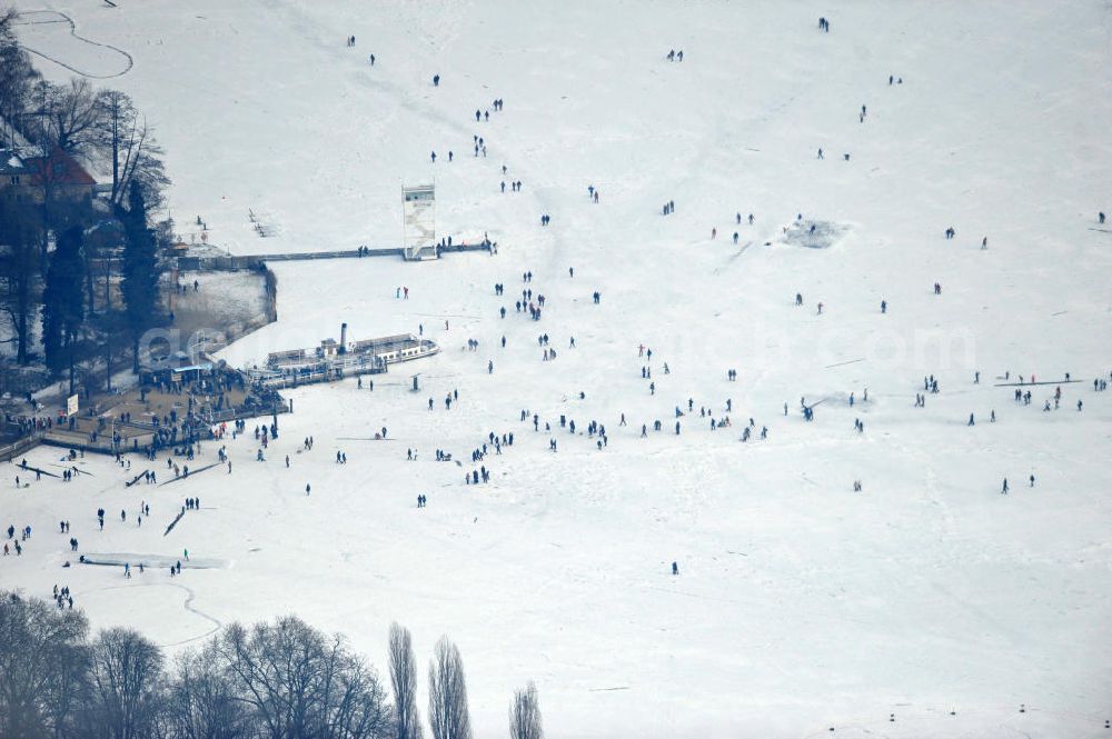 Aerial photograph Berlin - Hundreds of skaters and figure skating runners on the shore area of the Great Müggelsee on Müggelpark in Berlin. Ice skating is once again become a national pastime