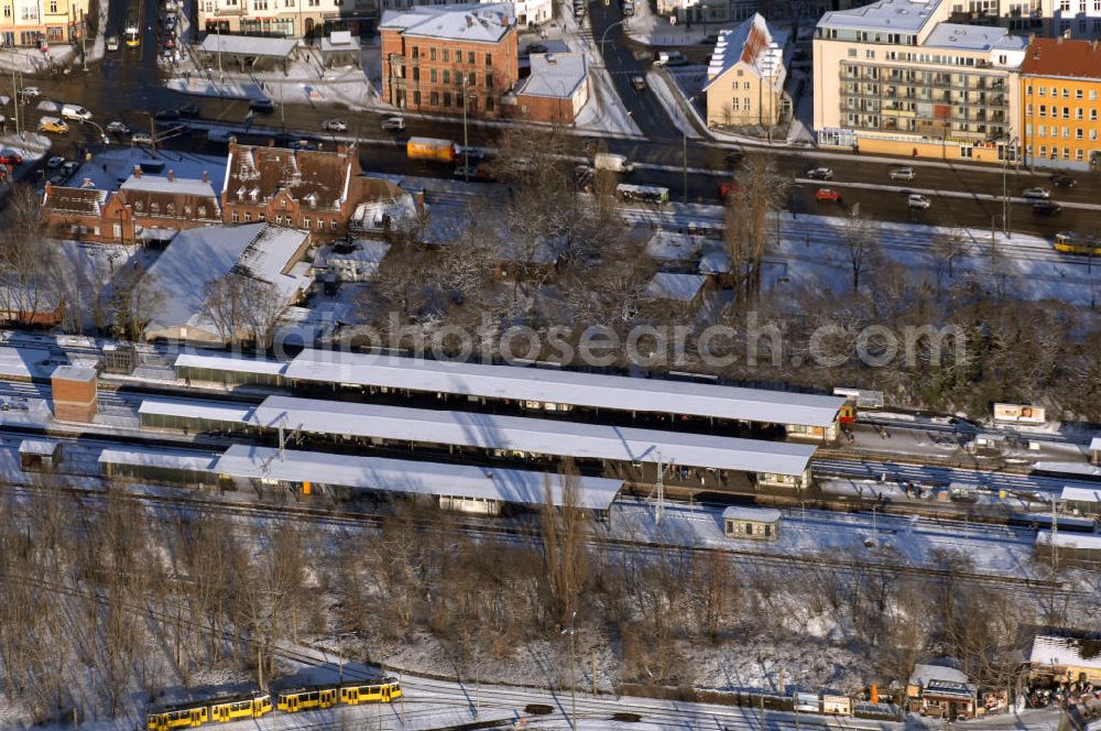 Berlin from the bird's eye view: Winterstimmung am schneebedecktem Bahnhof Berlin-Schöneweide, er ist ein Regional- und S-Bahnhof im Ortsteil Niederschöneweide im Berliner Bezirk Treptow-Köpenick. Der Bahnhof zählte zu den drei großen Fernbahnhöfen Ost-Berlins. Zum Bahnhof gehörte auch ein heute stillgelegter Rangierbahnhof. Im bahnamtlichen Betriebsstellenverzeichnis wird er unter BSWP (Berlin-Schöneweide Personenbahnhof) geführt.