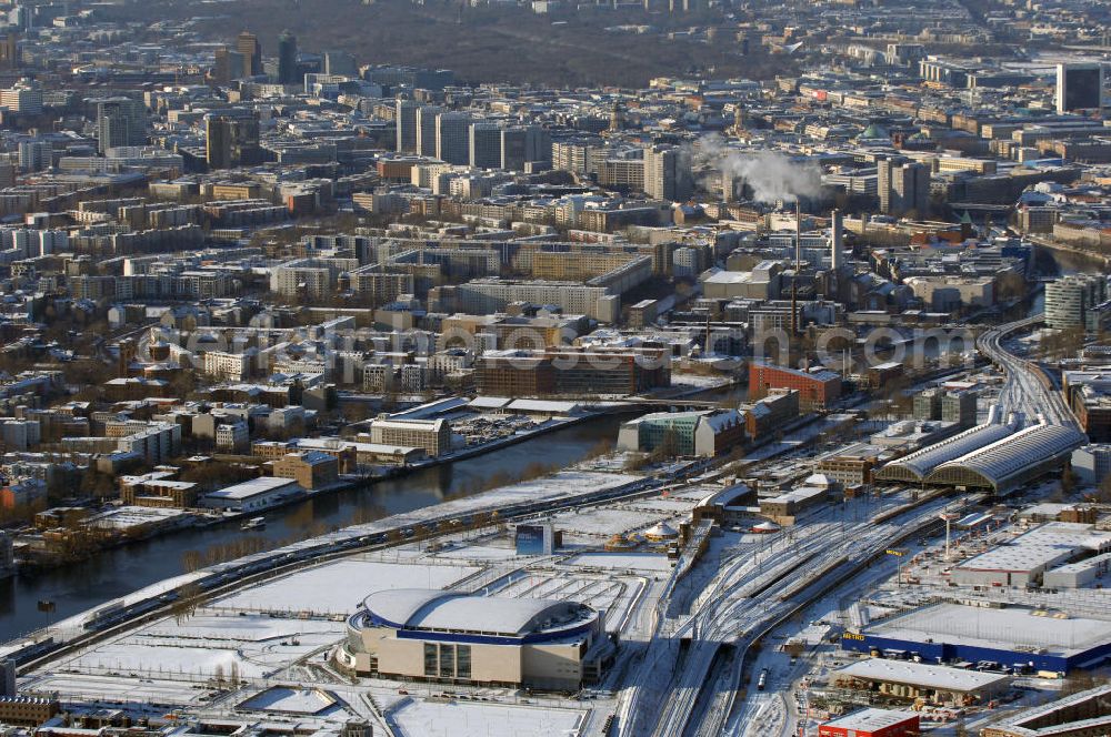 Berlin from the bird's eye view: Winterstimmung am schneebedeckter Stadtansicht vom Areal der O2 Arena in Berlin-Friedrichshain. Mit im Bild entlang des Spreeverlaufes der Berliner Ostbahnhof, Wohngebiete an der Leipziger Strasse und im Hintergrund der winterliche Berliner Tiergarten.