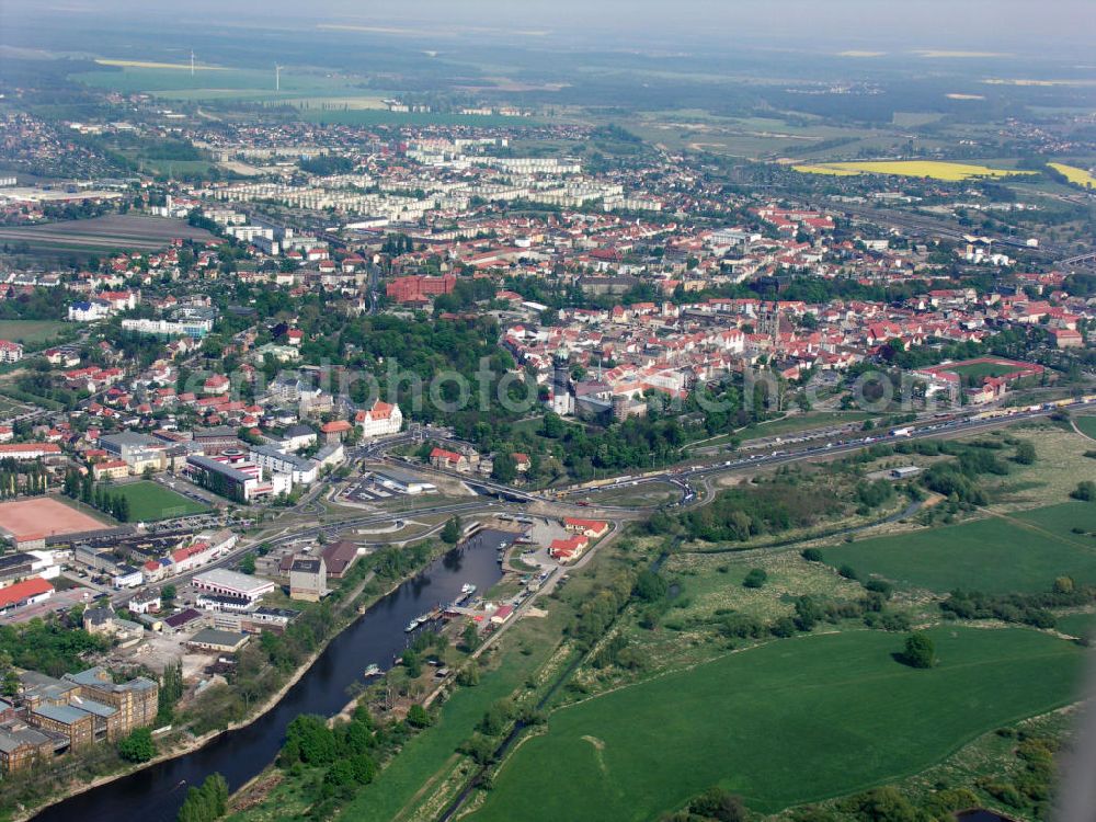 Aerial image Lutherstadt Wittenberg - Blick auf die Schlosskirche Wittenberg. Das Schloss mit seinem 88 m hohen neugotischen Kirchturm am westlichen Ende der Stadt zählt zum wichtigsten UNESCO-Weltkulturerbe. Die erste Erwähnung der Burg stammt von 1187. Im Jahre 1340 bauen die Askanier hier ihr eigenes Schloss. Die Urform der Schlosskirche muss 1496 in solch unzureichendem Zustand gewesen sein, dass nach deren Abriss ein Kirchneubau entstand, der erst 1506 beendet wurde. Berühmtheit erlangte sie, als am 31. Oktober 1517 der bis dahin nahezu unbekannte Wittenberger Augustinermönch und Theologieprofessor Martin Luther seine 95 lateinischen Disputationsthesen verbreitete. Heute befinden sich im Schloss eine Jugendherberge, das Riemer-Museum und die stadtgeschichtlichen Sammlungen.