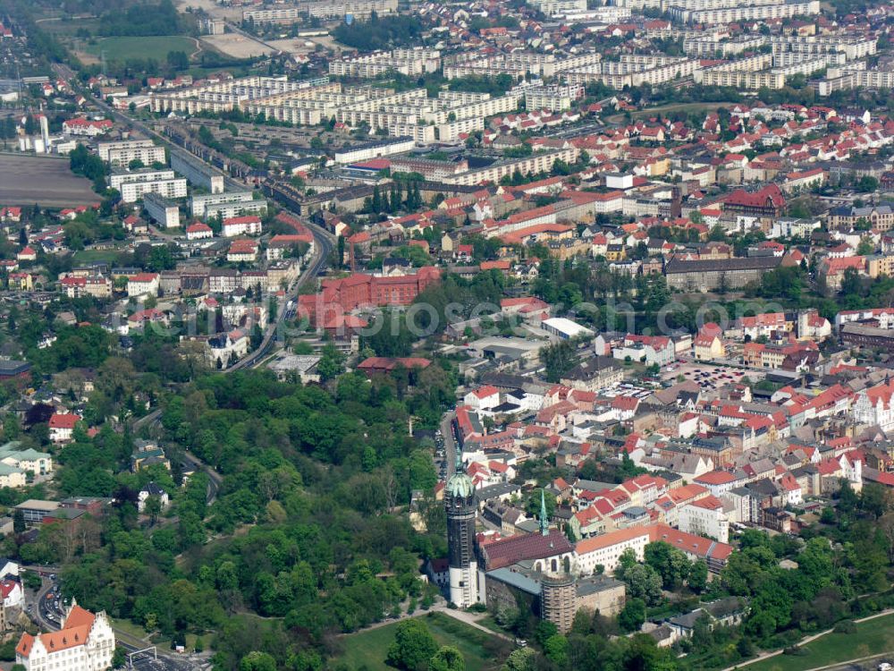 Aerial photograph Lutherstadt Wittenberg - Blick auf die Schlosskirche Wittenberg. Das Schloss mit seinem 88 m hohen neugotischen Kirchturm am westlichen Ende der Stadt zählt zum wichtigsten UNESCO-Weltkulturerbe. Die erste Erwähnung der Burg stammt von 1187. Im Jahre 1340 bauen die Askanier hier ihr eigenes Schloss. Die Urform der Schlosskirche muss 1496 in solch unzureichendem Zustand gewesen sein, dass nach deren Abriss ein Kirchneubau entstand, der erst 1506 beendet wurde. Berühmtheit erlangte sie, als am 31. Oktober 1517 der bis dahin nahezu unbekannte Wittenberger Augustinermönch und Theologieprofessor Martin Luther seine 95 lateinischen Disputationsthesen verbreitete. Heute befinden sich im Schloss eine Jugendherberge, das Riemer-Museum und die stadtgeschichtlichen Sammlungen.