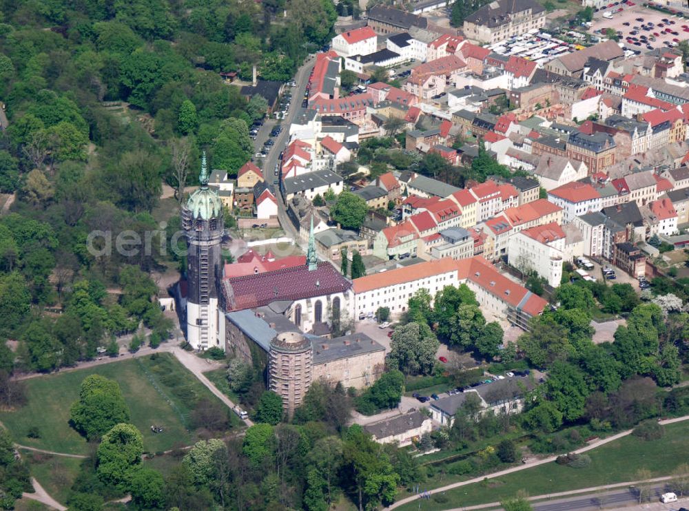 Lutherstadt Wittenberg from above - Blick auf die Schlosskirche Wittenberg. Das Schloss mit seinem 88 m hohen neugotischen Kirchturm am westlichen Ende der Stadt zählt zum wichtigsten UNESCO-Weltkulturerbe. Die erste Erwähnung der Burg stammt von 1187. Im Jahre 1340 bauen die Askanier hier ihr eigenes Schloss. Die Urform der Schlosskirche muss 1496 in solch unzureichendem Zustand gewesen sein, dass nach deren Abriss ein Kirchneubau entstand, der erst 1506 beendet wurde. Berühmtheit erlangte sie, als am 31. Oktober 1517 der bis dahin nahezu unbekannte Wittenberger Augustinermönch und Theologieprofessor Martin Luther seine 95 lateinischen Disputationsthesen verbreitete. Heute befinden sich im Schloss eine Jugendherberge, das Riemer-Museum und die stadtgeschichtlichen Sammlungen.