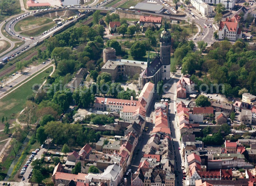 Aerial image Lutherstadt Wittenberg - Blick auf die Schlosskirche Wittenberg. Das Schloss mit seinem 88 m hohen neugotischen Kirchturm am westlichen Ende der Stadt zählt zum wichtigsten UNESCO-Weltkulturerbe. Die erste Erwähnung der Burg stammt von 1187. Im Jahre 1340 bauen die Askanier hier ihr eigenes Schloss. Die Urform der Schlosskirche muss 1496 in solch unzureichendem Zustand gewesen sein, dass nach deren Abriss ein Kirchneubau entstand, der erst 1506 beendet wurde. Berühmtheit erlangte sie, als am 31. Oktober 1517 der bis dahin nahezu unbekannte Wittenberger Augustinermönch und Theologieprofessor Martin Luther seine 95 lateinischen Disputationsthesen verbreitete. Heute befinden sich im Schloss eine Jugendherberge, das Riemer-Museum und die stadtgeschichtlichen Sammlungen.