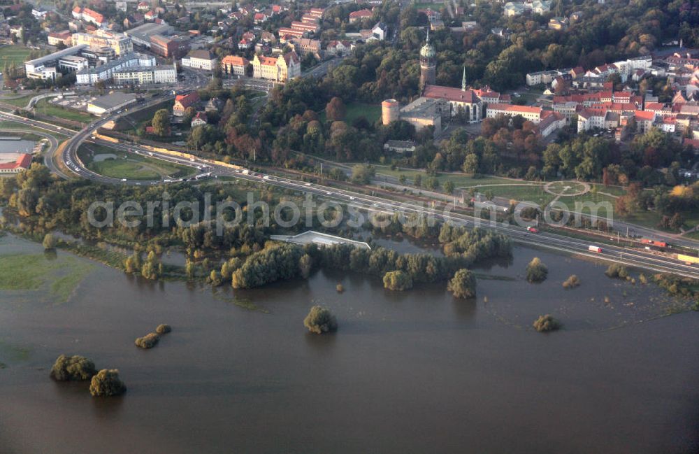 Lutherstadt Wittenberg from the bird's eye view: Blick auf die Schlosskirche Wittenberg. Das Schloss mit seinem 88 m hohen neugotischen Kirchturm am westlichen Ende der Stadt zählt zum wichtigsten UNESCO-Weltkulturerbe. Die erste Erwähnung der Burg stammt von 1187. Im Jahre 1340 bauen die Askanier hier ihr eigenes Schloss. Die Urform der Schlosskirche muss 1496 in solch unzureichendem Zustand gewesen sein, dass nach deren Abriss ein Kirchneubau entstand, der erst 1506 beendet wurde. Berühmtheit erlangte sie, als am 31. Oktober 1517 der bis dahin nahezu unbekannte Wittenberger Augustinermönch und Theologieprofessor Martin Luther seine 95 lateinischen Disputationsthesen verbreitete. Heute befinden sich im Schloss eine Jugendherberge, das Riemer-Museum und die stadtgeschichtlichen Sammlungen. .