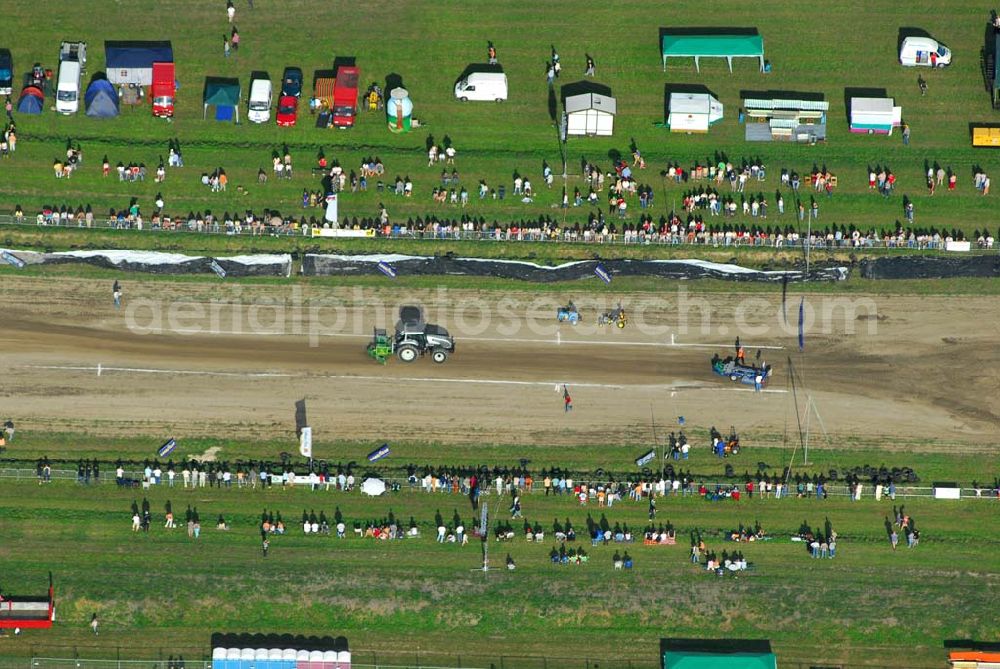 Aerial photograph Schmachtenhagen - : Wochenende der Deutsche Meisterschaften im Tractor-Pulling Klasse bis 8000 PS Nach Einbruch der Dunkelheit erwartet Sie wieder ein Nachtlauf der größten Tractor-Pulling Klasse bis 8000 PS. Gesucht wird der stärkste Traktor und der geschickteste Fahrer.Tractor Pulling. Hier gewinnt, wer mit seinem Traktor Marke Eigen- oder Umbau den Anhänger am weitesten zieht... Doch das ist leichter gesagt als getan, denn auf dem Bremswagen befindet sich bis zu 20 Tonnen Gewicht, welches sich während der Fahrt nach vorn bewegt und so die Last auf die Hinterradachse der Zugmaschine verlagert. Franz.Events bringt Ihnen dieses einmalige Spektakel direkt vor die Tür. Nun schon zum 3. Mal dürfen Sie sich auf Unterhaltung pur freuen.