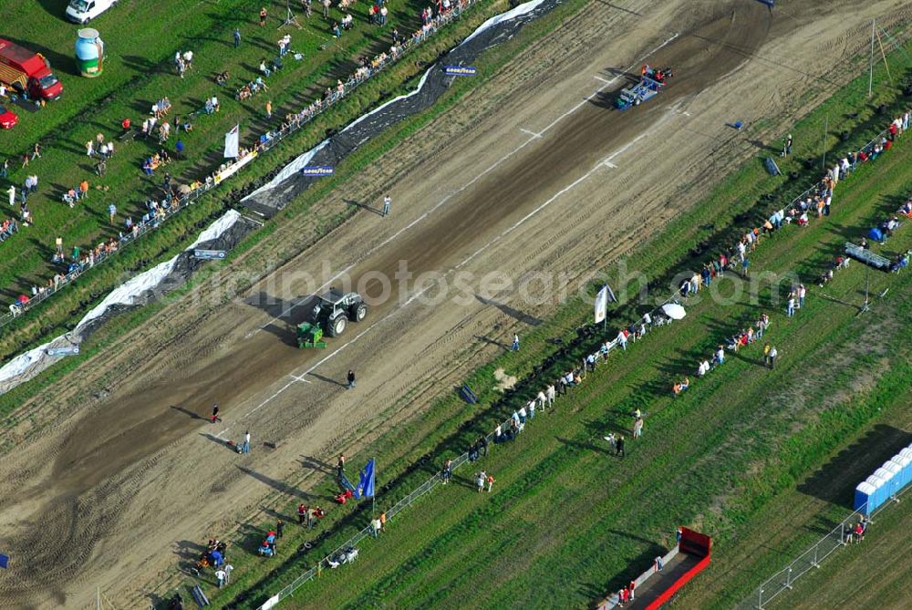 Aerial photograph Schmachtenhagen - : Wochenende der Deutsche Meisterschaften im Tractor-Pulling Klasse bis 8000 PS Nach Einbruch der Dunkelheit erwartet Sie wieder ein Nachtlauf der größten Tractor-Pulling Klasse bis 8000 PS. Gesucht wird der stärkste Traktor und der geschickteste Fahrer.Tractor Pulling. Hier gewinnt, wer mit seinem Traktor Marke Eigen- oder Umbau den Anhänger am weitesten zieht... Doch das ist leichter gesagt als getan, denn auf dem Bremswagen befindet sich bis zu 20 Tonnen Gewicht, welches sich während der Fahrt nach vorn bewegt und so die Last auf die Hinterradachse der Zugmaschine verlagert. Franz.Events bringt Ihnen dieses einmalige Spektakel direkt vor die Tür. Nun schon zum 3. Mal dürfen Sie sich auf Unterhaltung pur freuen.