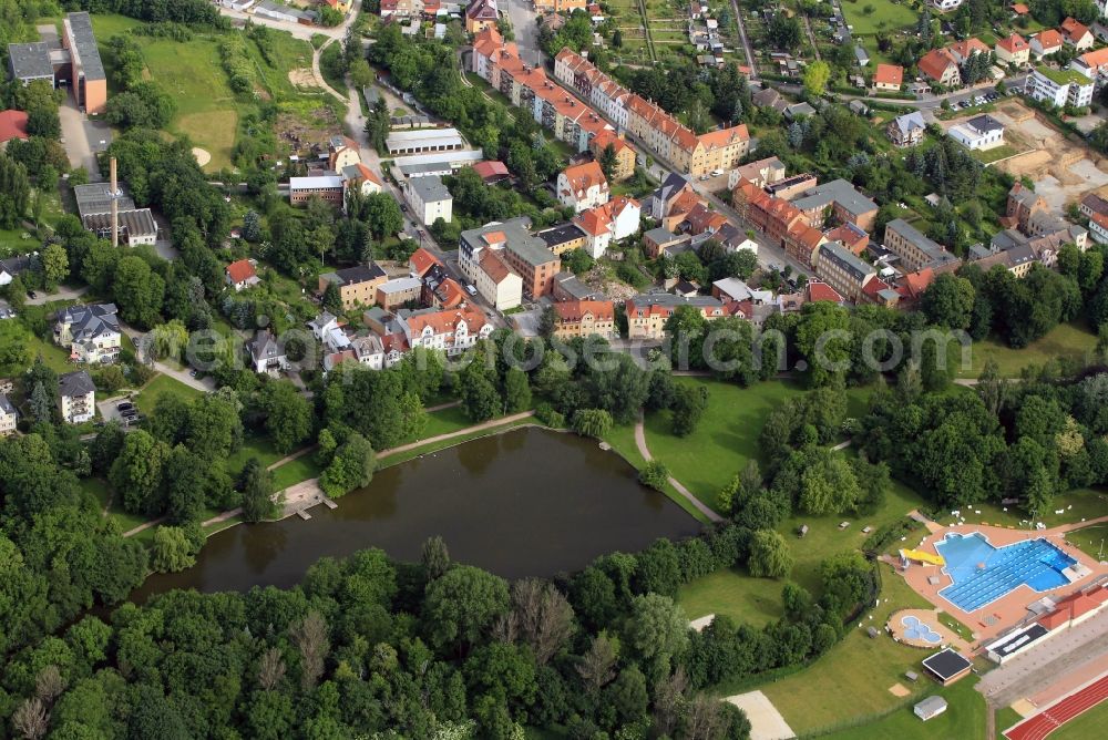 Apolda from above - The Friedensteich Pond and the adjacent outdoor pool are some of the leisure facilities in the south of the city Apolda in Thuringia. The natural location makes the adjacent residential area to a coveted address. For the painter and graphic artist Gerd Buschendorf who has his studio here, the area is as inspiring as for the type-I - Art School. On the road Auf dem Angespanne a special school has its place