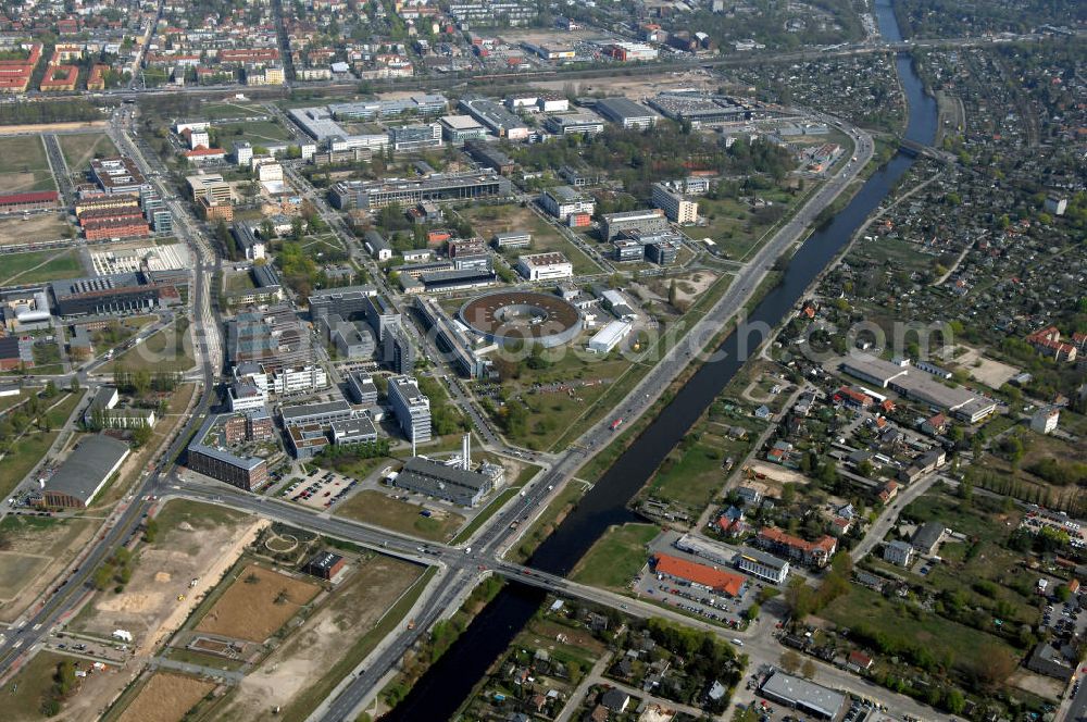 Aerial photograph Berlin - Blick auf das Gewerbegebiet Flugplatz Johannisthal / WISTA (links des Teltowkanals am Ernst-Ruska-Ufer) und dem Industrie und Wohngebieten rechts des Teltowkanals nördöstlich des Verlaufes der Stadtautobahn A 113.