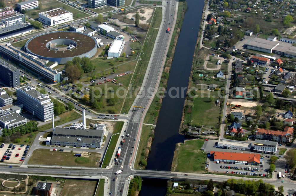 Aerial photograph Berlin - Blick auf das Gewerbegebiet Flugplatz Johannisthal / WISTA (links des Teltowkanals am Ernst-Ruska-Ufer) und dem Industrie und Wohngebieten rechts des Teltowkanals nördöstlich des Verlaufes der Stadtautobahn A 113.