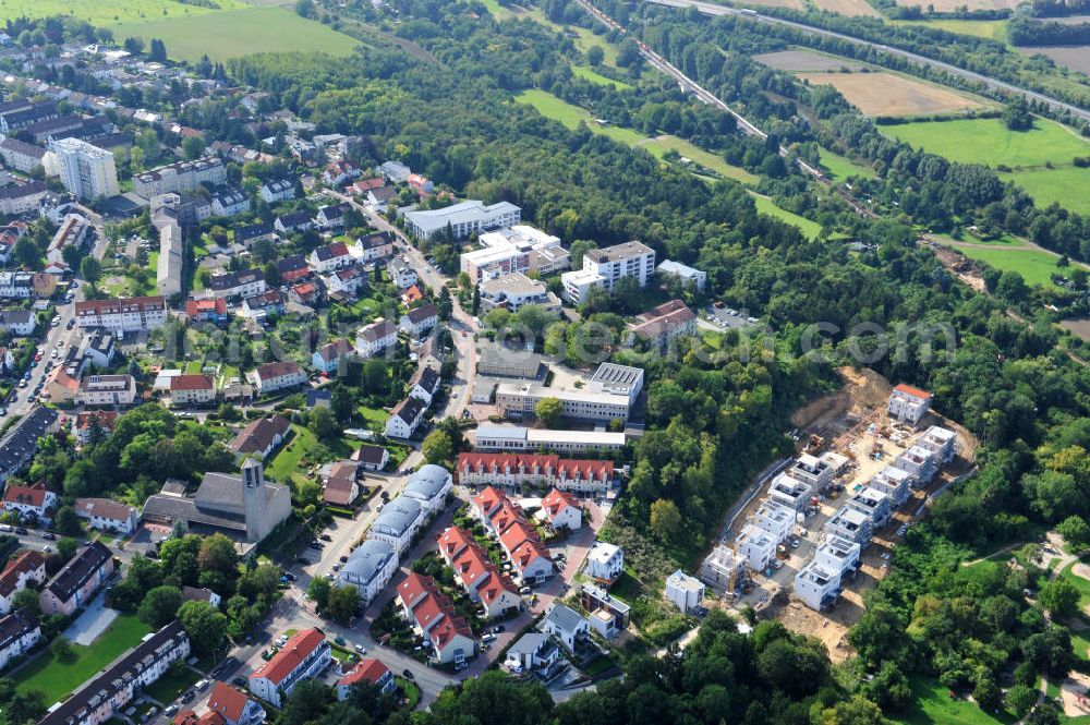 Bad Vilbel from the bird's eye view: Blick auf die Baustelle der Wohnanlage am Tannenweg der cds Wohnbau GmbH. In Waldrandlage entstehen hier mehrere Wohnneubauten durch die cds Wohnbau GmbH, einem Frankfurter Immobiliendienstleister. View the construction site of the residental complex on Tannenweg. At the forest are several new residential buildings built by the CDS Wohnbau GmbH, a Frankfurt real estate service provider.