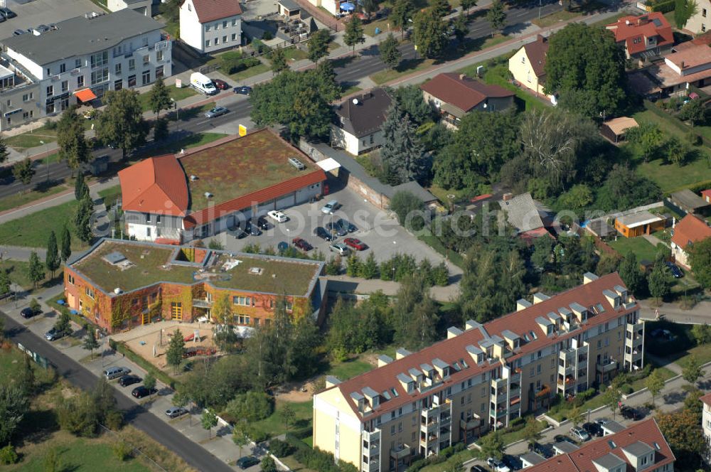 Berlin from the bird's eye view: Blick über ein Mehrfamilienhaus an der Strömannstraße auf den Kindergarten / Kita / Kindertagesstätte Sonnenblume am Hofzeichendamm und einen Netto Supermarkt an der Straße Zum Kappgraben in Karow.