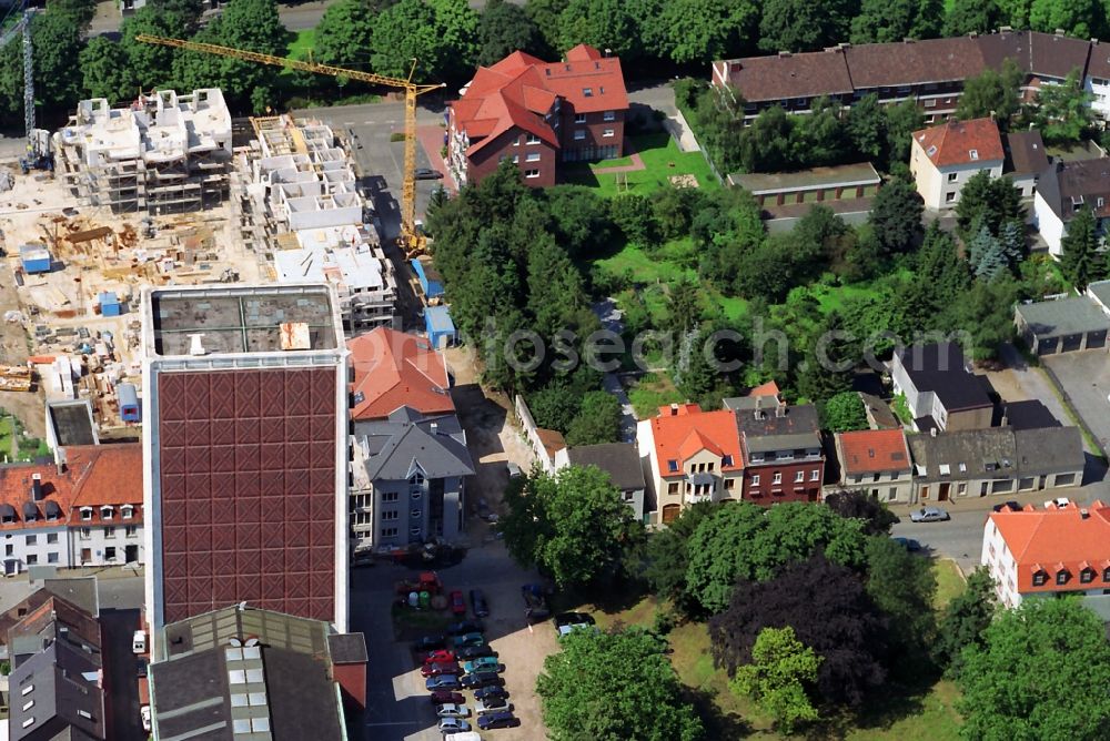 Rheinberg from above - View of construction works for a residential area and the former warehouse highrise of the spirits company Underberg Kraeuterturm in Rheinberg in the state North Rhine-Westphalia. The skyscraper at Kamper Strasse is landmarked as an industrial monument and is today being remodeled as as four-star Atlanta Hotel by the A.Real Estate GmbH