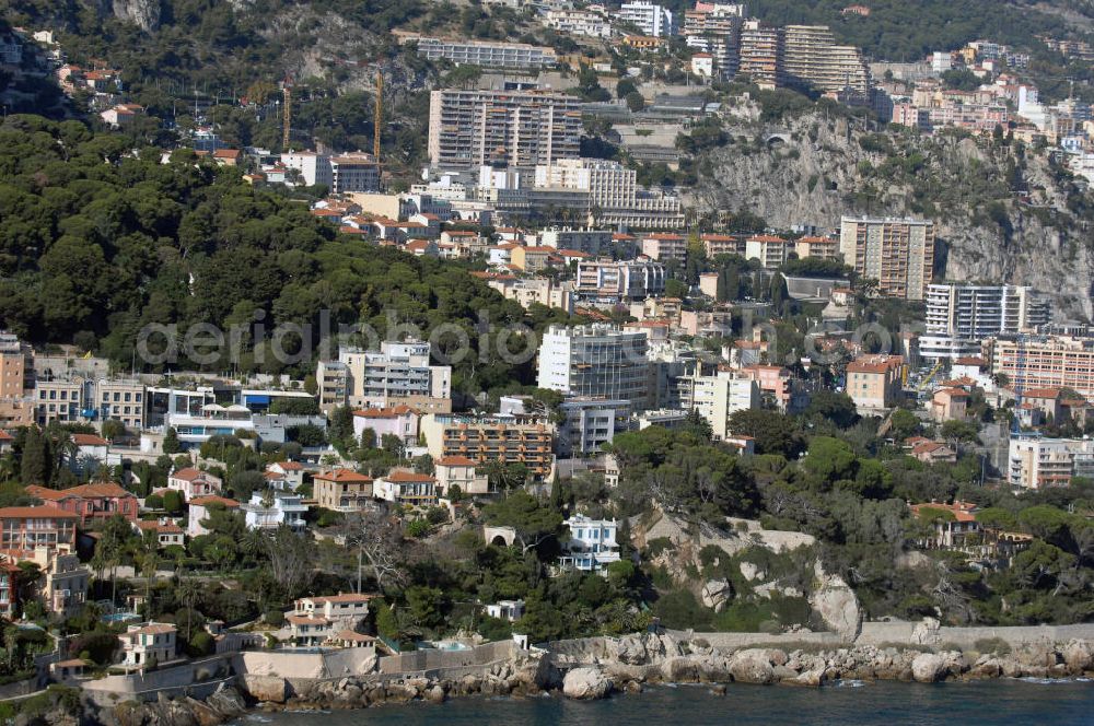 Cap-d' Ail from above - Blick auf ein Wohngebiet entlang der Avenue des Douaniers in Cap-d' Ail und auf den Stadtteil Fontvieille von Monaco. Cap-d' Ail ist ein kleiner französischer Badeort an der Cote d' Azur und Grenzort zum Fürstentum Monaco. Die deutsche Übersetzung des Namens lautet „Knoblauchkap“. Der Ort liegt am Fuße des steil aufragenden Bergs Tete de Chien bei La Turbie.Fontvieille ist ein Stadtbezirk (frz. quartier) im Fürstentum Monaco an der Cote d' Azur. Er stellt den südlichsten Teil des Stadtstaates dar, der auf einer Fläche von 32,4 ha etwa 3300 Einwohner (dies entspricht einem Zehntel der Bevölkerung des Landes) hat.