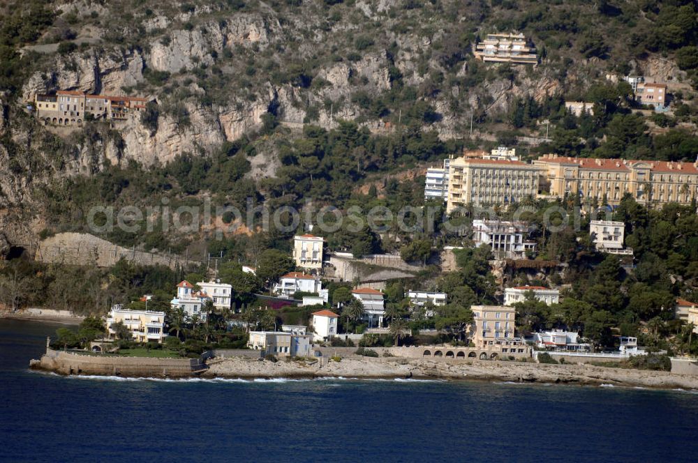 Cap-d' Ail from above - Blick auf ein Wohngebiet an der felsigen Küste und der Avenue Raymond Gramaglia in Cap-d' Ail. Cap-d' Ail ist ein kleiner französischer Badeort an der Cote d' Azur und Grenzort zum Fürstentum Monaco. Die deutsche Übersetzung des Namens lautet „Knoblauchkap“. Der Ort liegt am Fuße des steil aufragenden Bergs Tete de Chien bei La Turbie.