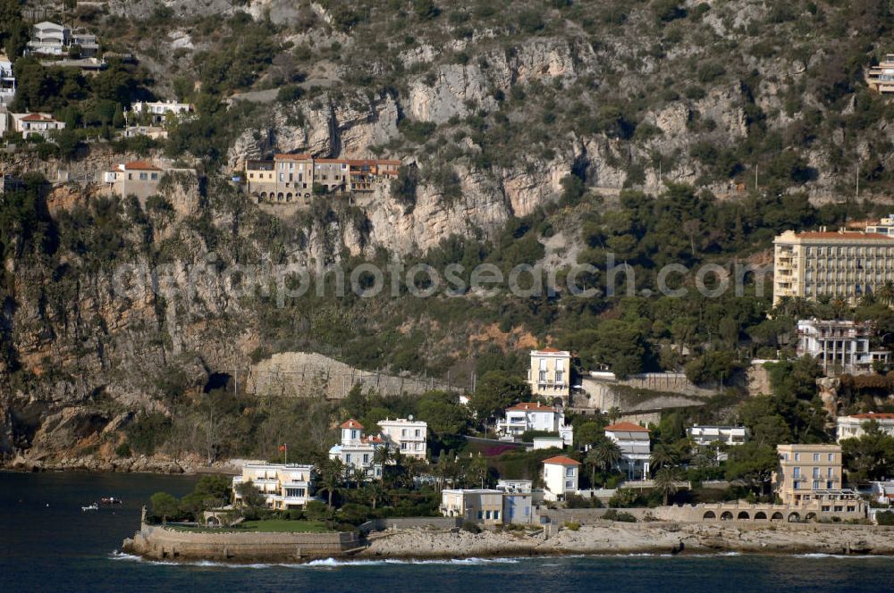 Aerial image Cap-d' Ail - Blick auf ein Wohngebiet an der felsigen Küste und der Avenue Raymond Gramaglia in Cap-d' Ail. Cap-d' Ail ist ein kleiner französischer Badeort an der Cote d' Azur und Grenzort zum Fürstentum Monaco. Die deutsche Übersetzung des Namens lautet „Knoblauchkap“. Der Ort liegt am Fuße des steil aufragenden Bergs Tete de Chien bei La Turbie.