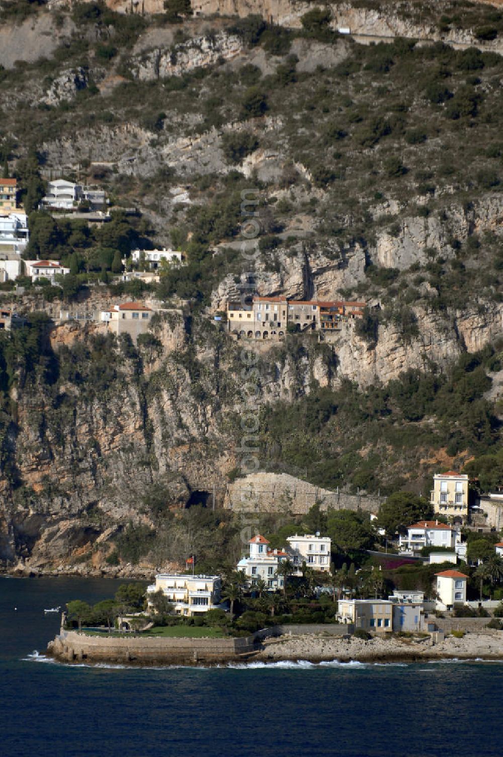 Aerial photograph Cap-d' Ail - Blick auf ein Wohngebiet an der felsigen Küste und der Avenue Raymond Gramaglia in Cap-d' Ail. Cap-d' Ail ist ein kleiner französischer Badeort an der Cote d' Azur und Grenzort zum Fürstentum Monaco. Die deutsche Übersetzung des Namens lautet „Knoblauchkap“. Der Ort liegt am Fuße des steil aufragenden Bergs Tete de Chien bei La Turbie.