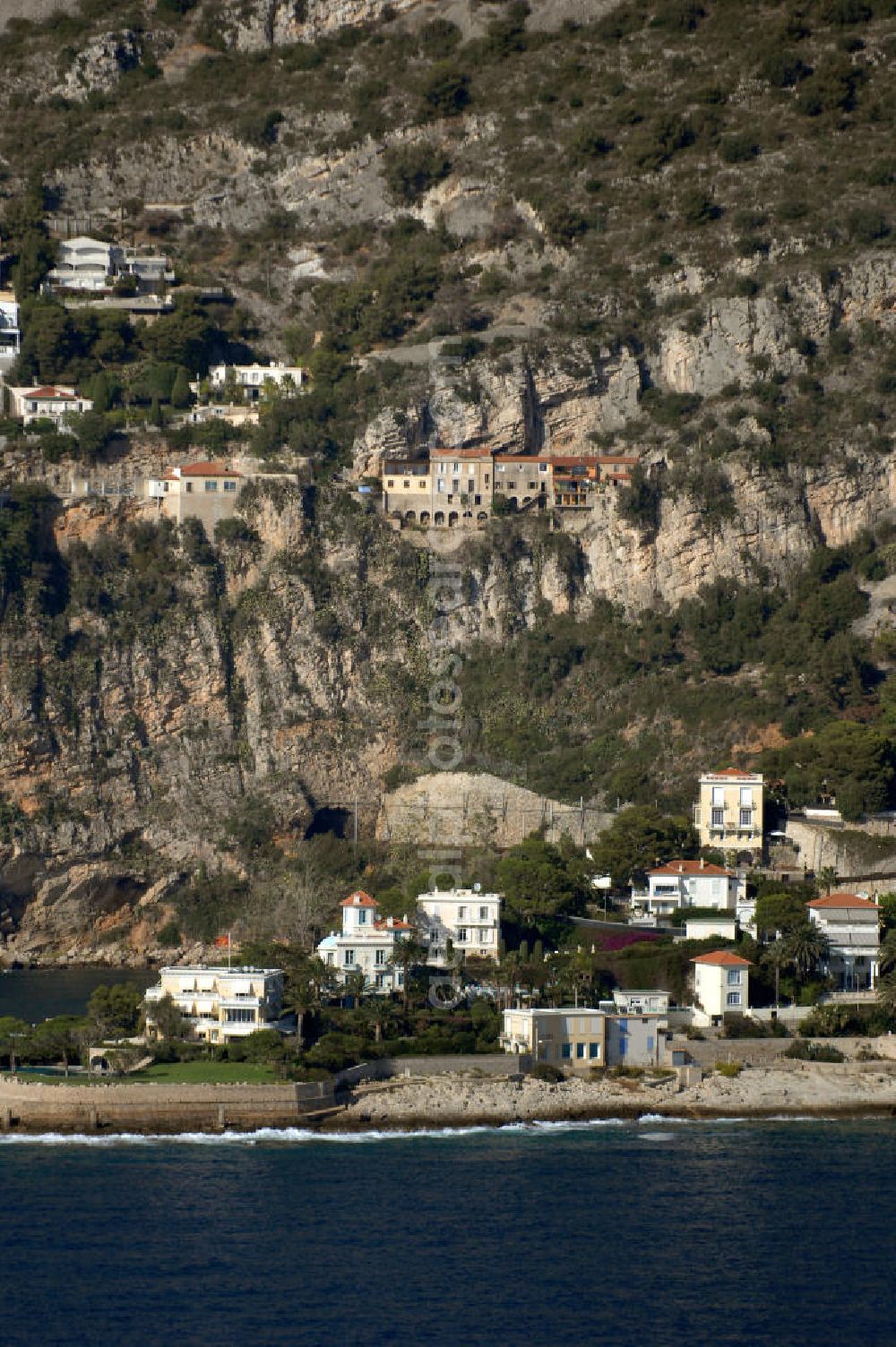 Cap-d' Ail from above - Blick auf ein Wohngebiet an der felsigen Küste und der Avenue Raymond Gramaglia in Cap-d' Ail. Cap-d' Ail ist ein kleiner französischer Badeort an der Cote d' Azur und Grenzort zum Fürstentum Monaco. Die deutsche Übersetzung des Namens lautet „Knoblauchkap“. Der Ort liegt am Fuße des steil aufragenden Bergs Tete de Chien bei La Turbie.