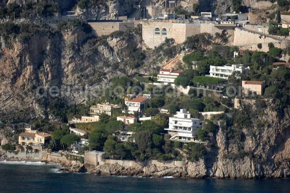 Cap-d' Ail from above - Blick auf ein Wohngebiet an der felsigen Küste und der Avenue du 3. Septembre in Cap-d' Ail. Cap-d' Ail ist ein kleiner französischer Badeort an der Cote d' Azur und Grenzort zum Fürstentum Monaco. Die deutsche Übersetzung des Namens lautet „Knoblauchkap“. Der Ort liegt am Fuße des steil aufragenden Bergs Tete de Chien bei La Turbie.