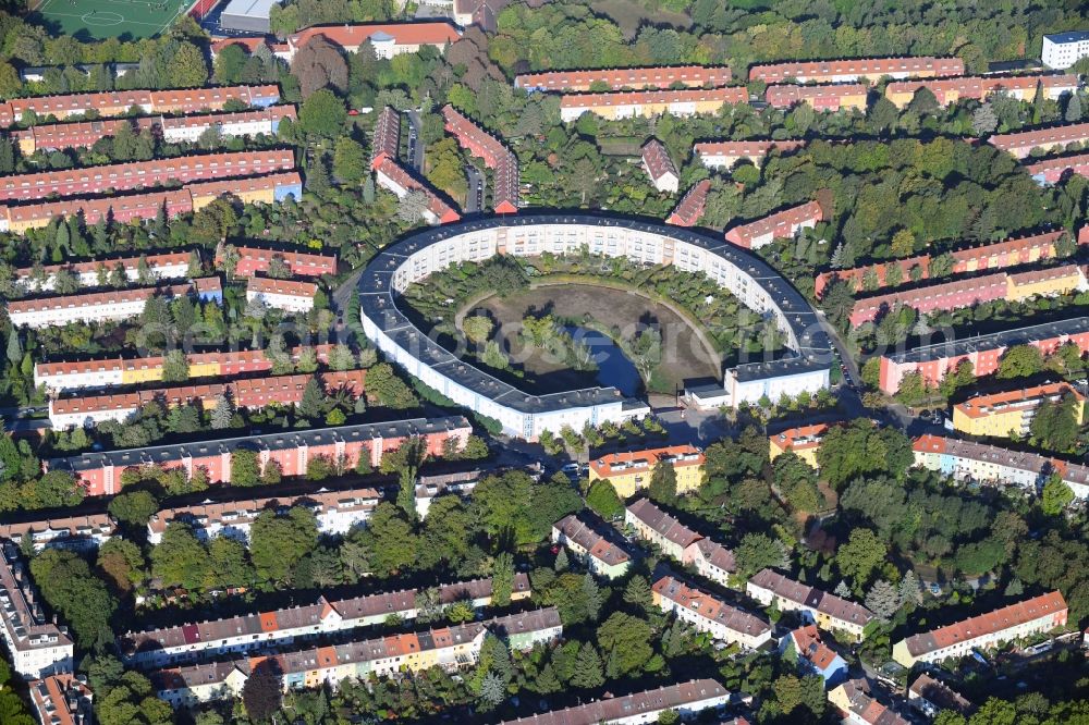 Berlin from the bird's eye view: View of the Horseshoe estate in the Britz part of the district of Neukoelln in Berlin. The Hufeisensiedlung was designed by Bruno Taut and Martin Wagner. It is one of the first projects of social housing and part of the larger settlement Britz - Fritz Reuter city. It is an UNESCO World Heritage Site. The horseshoe itself is still owned by the GEHAG, under the roof of the Deutsche Wohnen AG