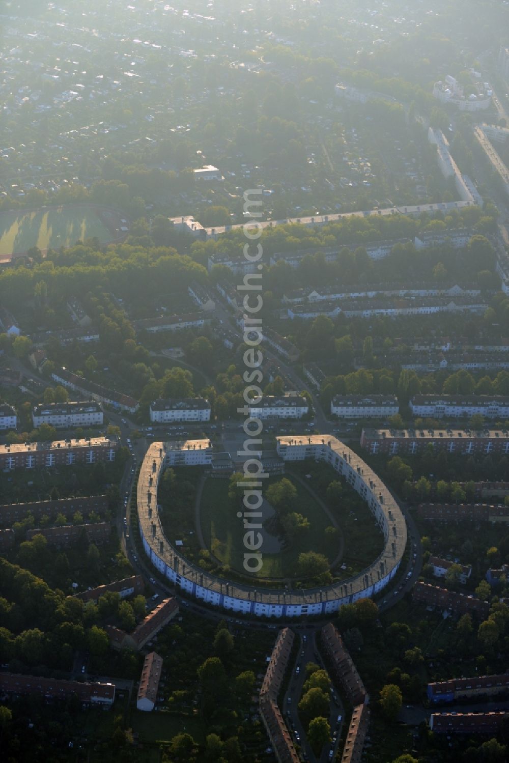 Berlin from the bird's eye view: View of the Horseshoe estate in the Britz part of the district of Neukoelln in Berlin. The Hufeisensiedlung was designed by Bruno Taut and Martin Wagner. It is one of the first projects of social housing and part of the larger settlement Britz / Fritz Reuter city. It is an UNESCO World Heritage Site. The horseshoe itself is still owned by the GEHAG, under the roof of the Deutsche Wohnen AG