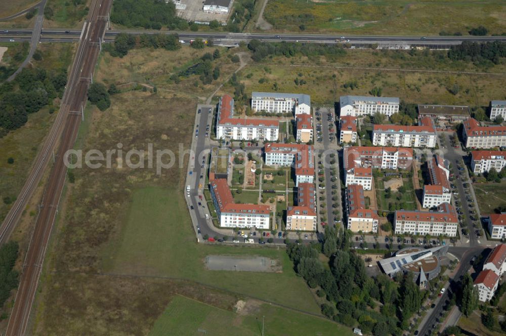 Berlin from the bird's eye view: Blick auf die Karestraße mit der Kita / Kindertagesstätte Krümelkiste, die Pfannschmidtstraße Ecke Achillesstraße mit dem Jugendclub im Wohngebiet / Neubaugebiet Karow-Nord direkt neben Schienen / Bahngleisen und der Autobahn A10 / E65.