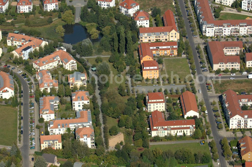 Aerial photograph Berlin - Blick auf Mehrfamilienhäuser an der Busonistraße und am Achtrutenberg mit Parkanlage und Teich im Wohngebiet / Neubaugebiet Karow-Nord.