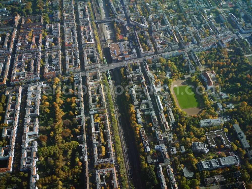 Berlin from the bird's eye view: Residential area around ringbahn rail line and Hermannstrasse in the North of the Britz part of the district of Neukoelln in Berlin. Hertabruecke Bridge is located in the background and a football pitch in the South of the rail line