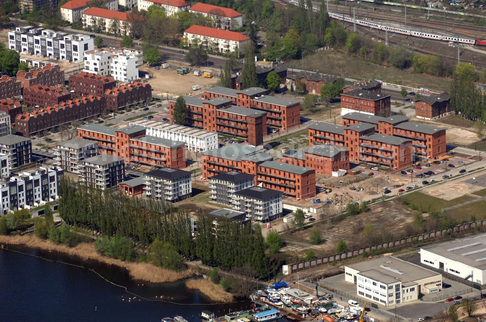 Berlin from the bird's eye view: Blick auf das Rummelsburger Ufer, ein Teil der Rummelsburger Bucht mit dem Rummelsburger See. Hier enstehen bzw. entstanden Wohnungen als auch Einfamilienhaäuser im Neubau und Altbau. Speziell hierfür umgebaut sind die denkmalgeschützten ehemaligen JVA Gebäude der Haftanstalt / Justizvollzugsanstalt Rummelsburg. Einbezogen in die Bautätigkeit wurden sechs so genannten Verwahrhäuser des Gefängnisses, der Turm des ehemaligen Heizhauses, das Wäschereigebäude sowie das einstige Lazarett.