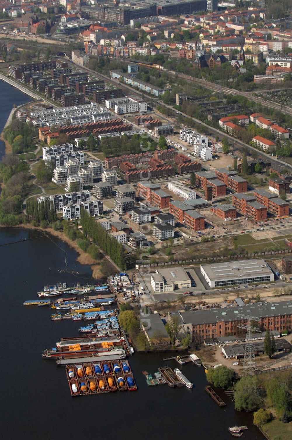 Aerial image Berlin - Blick auf das Rummelsburger Ufer, ein Teil der Rummelsburger Bucht mit dem Rummelsburger See. Hier enstehen bzw. entstanden Wohnungen als auch Einfamilienhaäuser im Neubau und Altbau. Speziell hierfür umgebaut sind die denkmalgeschützten ehemaligen JVA Gebäude der Haftanstalt / Justizvollzugsanstalt Rummelsburg. Einbezogen in die Bautätigkeit wurden sechs so genannten Verwahrhäuser des Gefängnisses, der Turm des ehemaligen Heizhauses, das Wäschereigebäude sowie das einstige Lazarett.