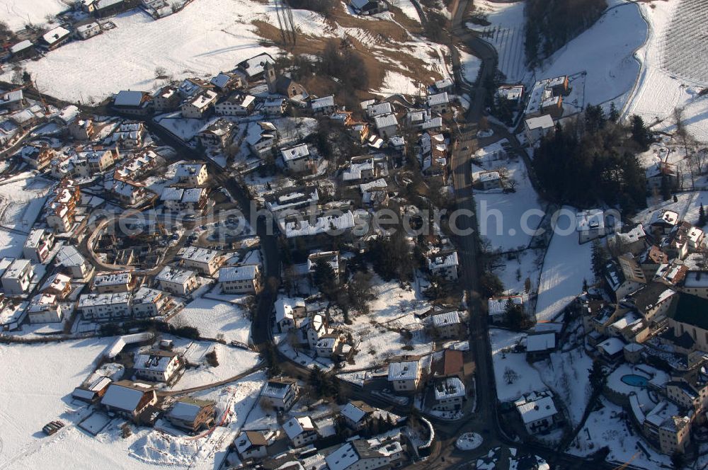 Voels from the bird's eye view: Blick auf das winterlich verschneite Wohngebiet mit Hang von Voels am Schlern (Fiè Allo Sciliar) in Italien.