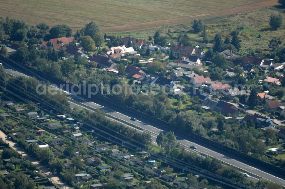 Berlin from above - Blick durch eine Stromleitung / Strommast von einer Kleingartensiedlung in Buch über die Autobahn A 10 / E 55 auf Einfamilienhäuser am Siedlungsring in Karow.