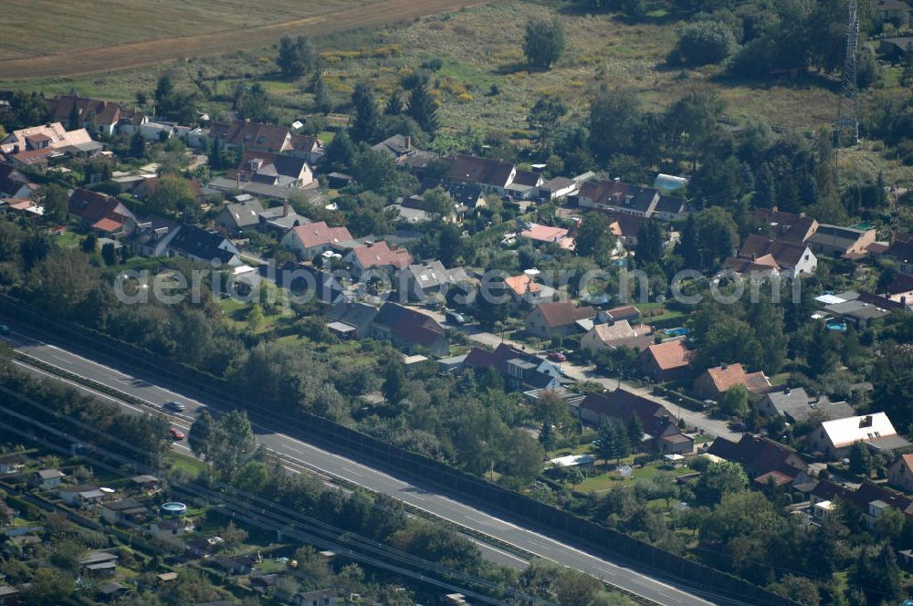 Berlin from the bird's eye view: Blick durch eine Stromleitung / Strommast von einer Kleingartensiedlung in Buch über die Autobahn A 10 / E 55 auf Einfamilienhäuser am Siedlungsring in Karow.