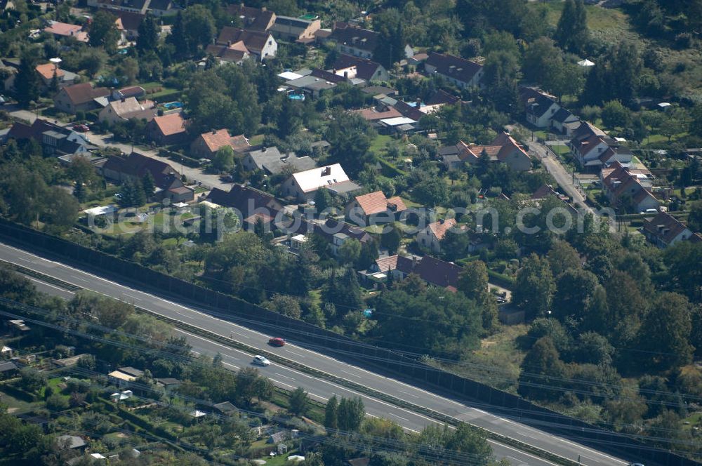 Aerial image Berlin - Blick durch eine Stromleitung / Strommast von einer Kleingartensiedlung in Buch über die Autobahn A 10 / E 55 auf Einfamilienhäuser am Siedlungsring in Karow.