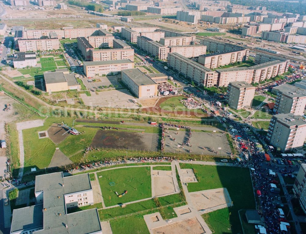 Aerial image Berlin - Residential area laid along the street in the city of Cottbus Hellersdorf district of Berlin. Pictured people rush at the sports ground today Wolfgang Amadeus Mozart-school Helicopters - Helicopter flights with a INTERFLUG Russian-built helicopter type Mi-8. n the background the subway station Hellersdorf