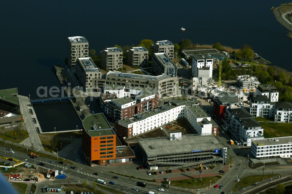 Aerial photograph Rostock - Multi-family housing estate, commercial building, parking garage and hotel complex on the wooden peninsula in Rostock in the state Mecklenburg-Western Pomerania, Germany