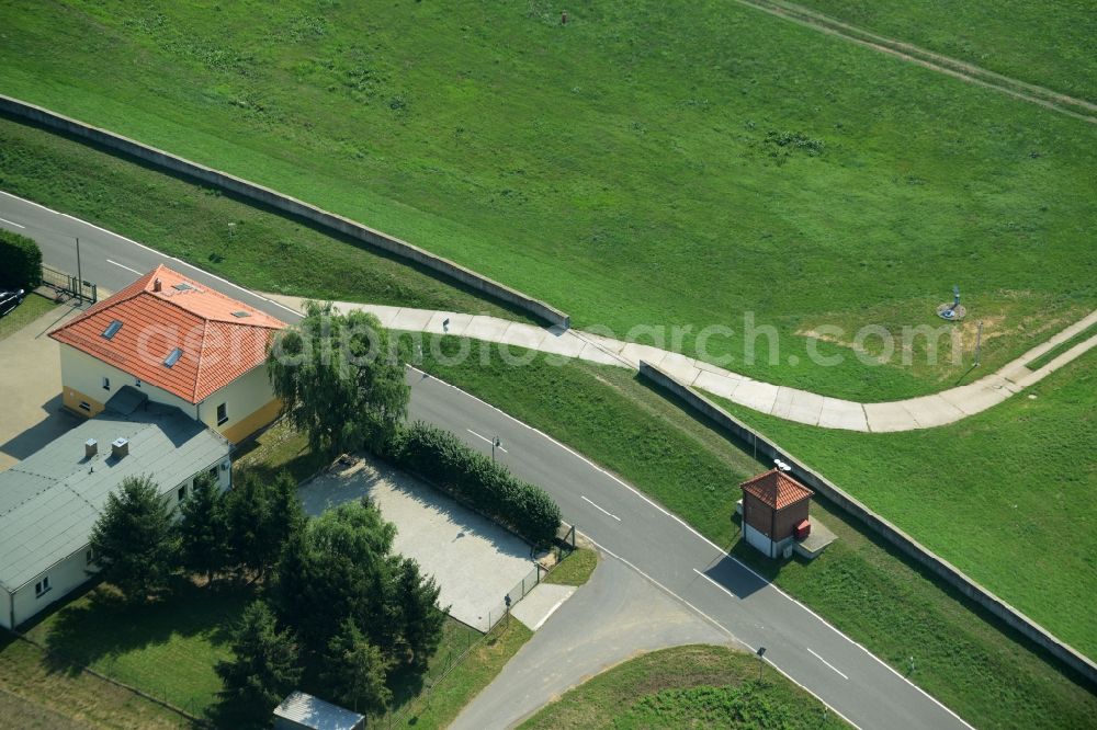 Aerial image Mauken - Residential building, wall and path in Mauken in the state of Saxony-Anhalt. A wall divided by a concrete slab path is standing opposite the house