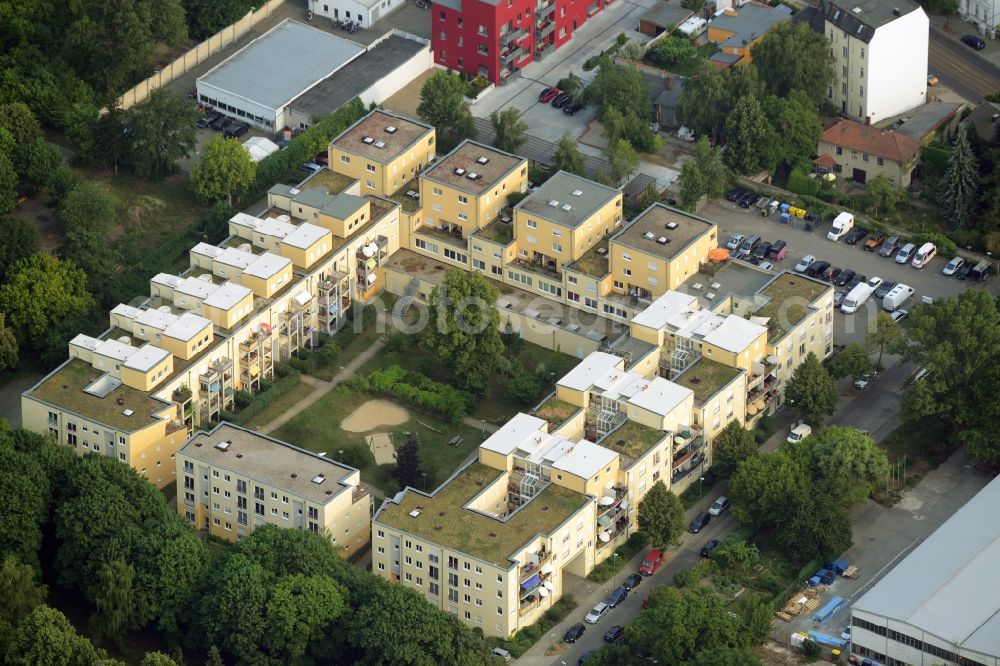 Aerial photograph Berlin - Residential estate on Charlotte-E.-Pauly-Strasse in the Friedrichshagen part of the district of Treptow-Koepnick in Berlin. The square compound includes a yard with park and playground and several residential and apartment buildings. The roofs, balconies and terraces are especially distinct