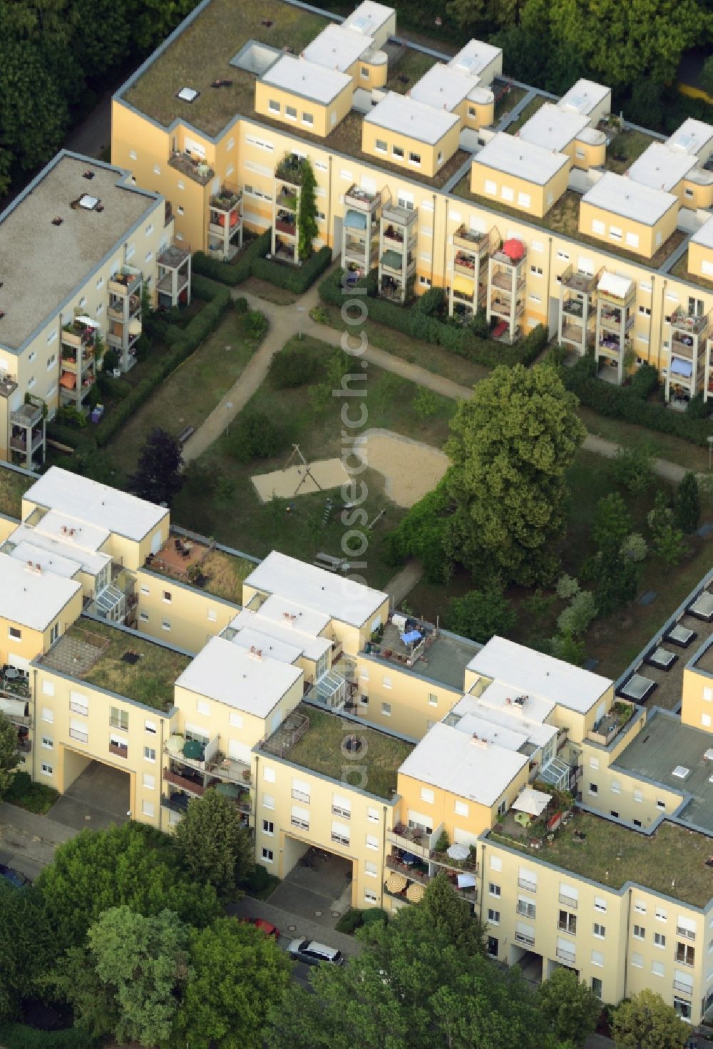 Berlin from the bird's eye view: Residential estate on Charlotte-E.-Pauly-Strasse in the Friedrichshagen part of the district of Treptow-Koepnick in Berlin. The square compound includes a yard with park and playground and several residential and apartment buildings. The roofs, balconies and terraces are especially distinct