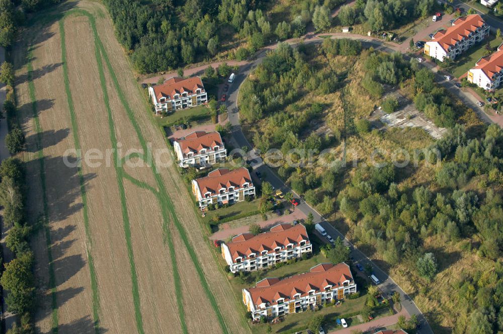 Aerial photograph Panketal - Blick auf Mehrfamilienhäuser am Eichenring direkt neben einer landwirtschaftlichen Nutzfläche / einem Feld in der Gemeinde Panketal Ortsteil Schwanebeck in Neu-Buch.