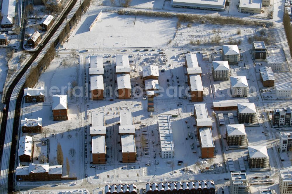 Aerial photograph Berlin - Blick auf das winterlich verschneite Wohngebiet auf dem Gelände der ehemaligen Haftanstalt Rummelsburg an der Hauptstraße, der heutigen Wohnanlage Berlin Campus. Modern umgebaut und saniert wurden die sechs Verwahrhäuser aus den Jahren 1877 bis 1879. Die Berliner Maruhn-Immobiliengruppe hatte das Grundstück im Januar 2007 nach 17 Jahren schleichendem Verfall erworben. Sie investiert zusammen mit der Grundstein Bauträger GmbH.