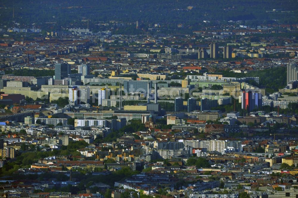 Aerial image Berlin - Vom Szenebezirk Kreuzberg von Berlin zieht sich ein urbanes Stadtquartier mit großflächigen Wohnarealen bis in die Neubauviertel von Berlin-Mitte. Als grüne Oase durchzieht der Leuschnerdamm vom Oranienplatz kommend über das Engelbecken bis zur Michaelkirche das Wohngebiet. Das Heizkraftwerk Mitte versorgt die umliegenden Wohnungen mit Fernwärme und elektrischem Strom. In den drei markanten Hochhäusern haben die Berliner Verkehrsbetriebe ihren Sitz. Weithin sichtbar sind das Rathaus Mitte in der Berolinastraße und das Etaphotel in der Mollstraße. Im Hintergrund sind die Hochhäuser am Ernst-Thälmann-Park zu erkennen.// From the trendy district of Kreuzberg in Berlin, a urban quarter draws with large living areas to the new district of Berlin-Mitte. As a green oasis of Leuschnerdamm from Oranienplatz Coming pervades over the Engelbecken to Michael's Church the residential area. The heating plant center supplies the surrounding apartments with district heating and electricity. In the three distinctive high-rise buildings the Berlin transport companies have their headquarters. In the background the skyscrapers at Ernst Thalmann Park can be seen.