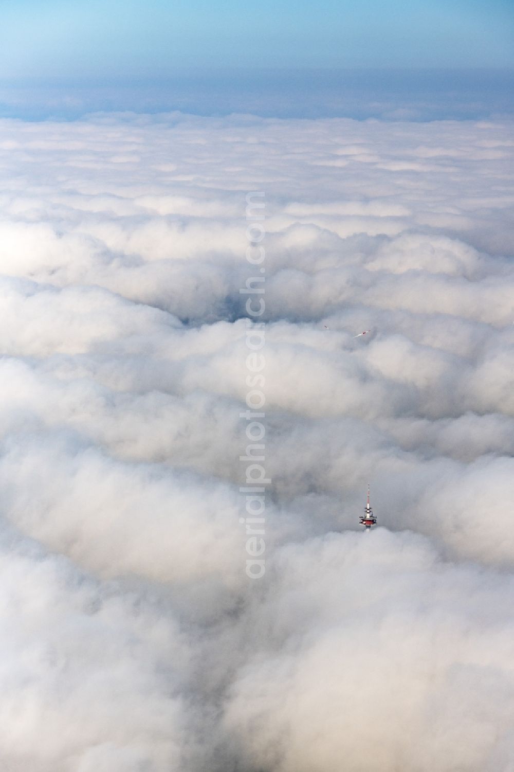 Burgsalach from above - Weather-dependent telecommunications tower structure and television tower enveloped by a layer of cloud in Burgsalach in the state Bavaria, Germany