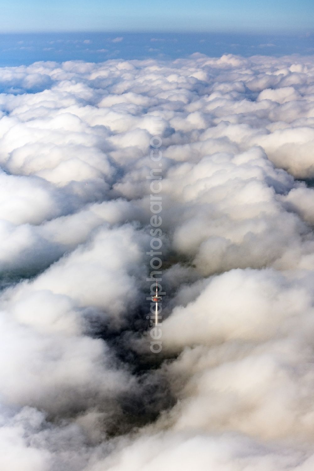 Burgsalach from above - Weather-dependent telecommunications tower structure and television tower enveloped by a layer of cloud in Burgsalach in the state Bavaria, Germany