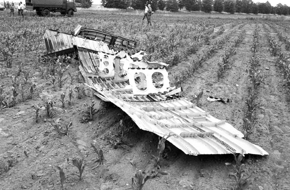 Aerial photograph Schönefeld - Blick auf das Wrack der INTERFLUG Iljuschin IL62 mit der Kennung DDR-SEW auf dem Gelände des Flughafens Berlin-Schönefeld.Am 17.Juni 1989 wurde die Maschine bei einem Startabbruch zerstört. Da bei dem Startabbruch die Triebwerke versehentlich abgestellt wurden, anstatt vollen Umkehrschub zu geben, überrollte das Luftfahrzeug das Ende der Start- und Landebahn. Der Rumpf brach auseinan der und ging in Flammen auf. Es kamen 21 Menschen ums Leben. Die Wrackteile wurden in wochenlanger Kleinstarbeit geborgen, der restliche, in den Tragflächensektionen verbliebene Kerosinbestand enttankt. Wrackteile sollen auf dem Geländes des ehemaligen Südteiles Diepensee des einstigen INTERFLUG-Zentralflughafens vergraben worden sein.